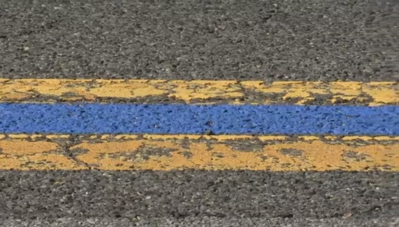 blue line between yellow lines on road